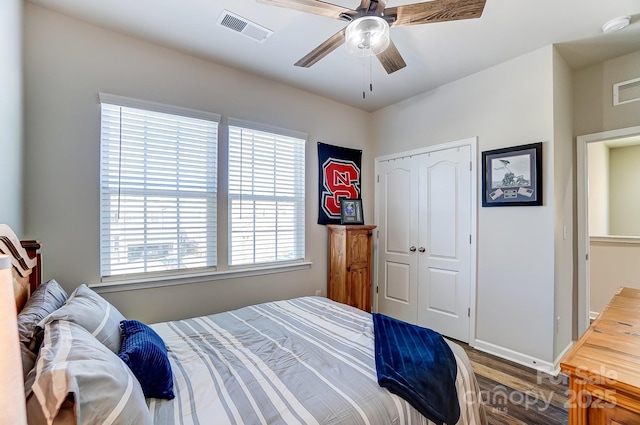 bedroom featuring ceiling fan, multiple windows, hardwood / wood-style flooring, and a closet