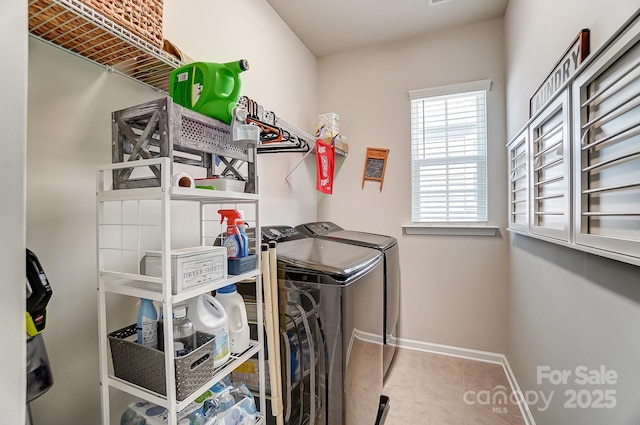 clothes washing area featuring tile patterned flooring and washer and dryer