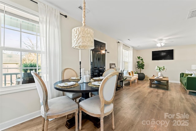 dining area with hardwood / wood-style flooring and ceiling fan