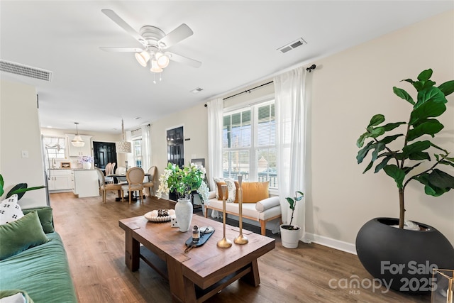 living room with dark wood-type flooring and ceiling fan