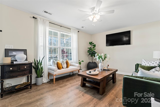 living room featuring wood-type flooring and ceiling fan