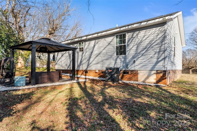 view of home's exterior featuring a gazebo, a yard, and central air condition unit