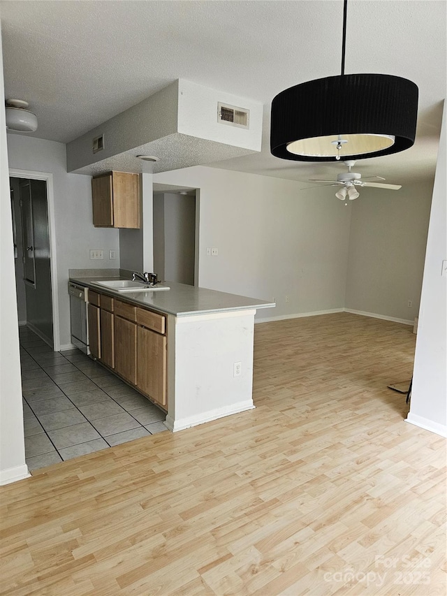 kitchen with dishwashing machine, ceiling fan, visible vents, and light wood finished floors