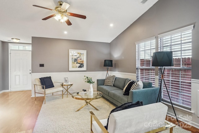 living room featuring ceiling fan, light hardwood / wood-style flooring, and lofted ceiling