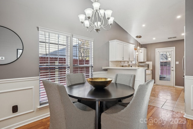 dining space featuring light tile patterned floors, lofted ceiling, and a chandelier