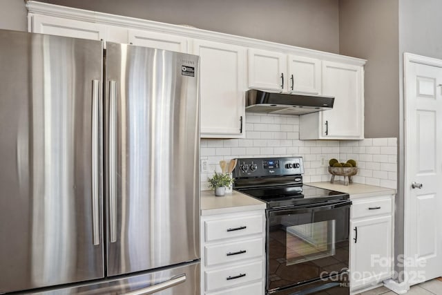 kitchen featuring black electric range oven, white cabinetry, decorative backsplash, and stainless steel fridge