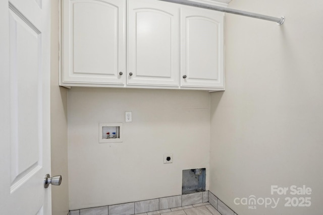 laundry room featuring electric dryer hookup, cabinets, washer hookup, and light tile patterned floors