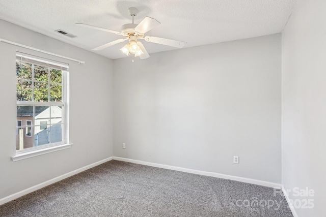 carpeted spare room featuring a textured ceiling and ceiling fan