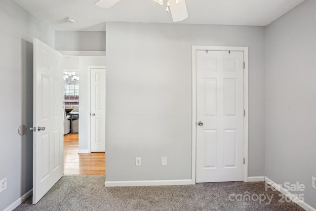 unfurnished bedroom with a textured ceiling, carpet floors, and ceiling fan