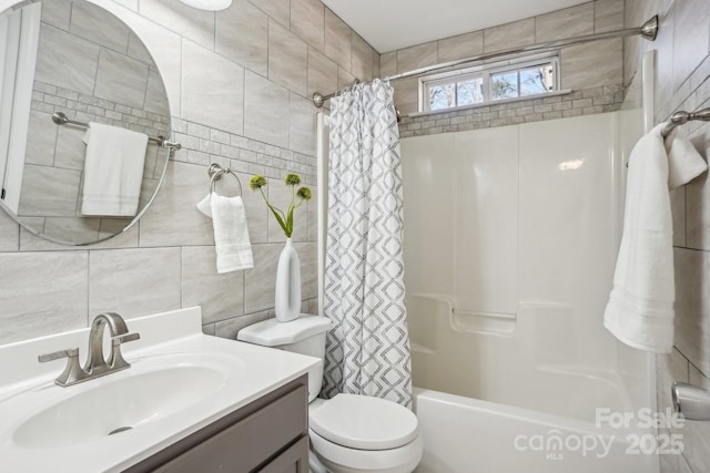 full bathroom with vanity, toilet, tile walls, and shower / bath combo with shower curtain