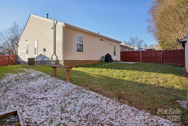 back of house with central AC unit and a yard