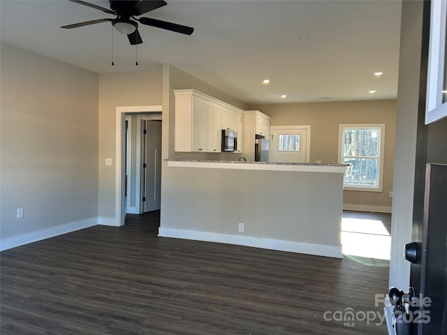 interior space featuring ceiling fan and dark hardwood / wood-style flooring