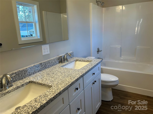 full bathroom with hardwood / wood-style floors, toilet, vanity, and shower / washtub combination