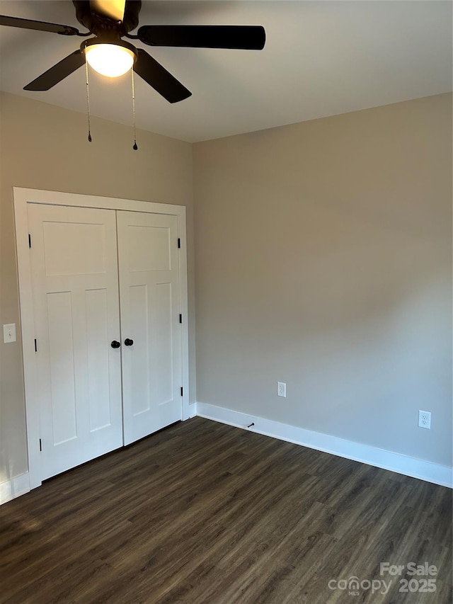 unfurnished bedroom featuring ceiling fan, dark hardwood / wood-style floors, and a closet