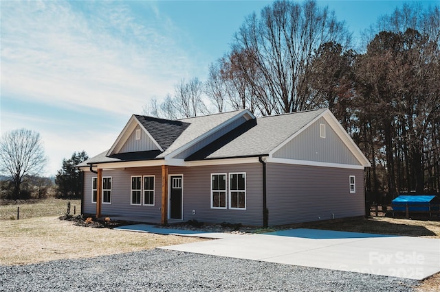 view of front of property featuring driveway and a shingled roof