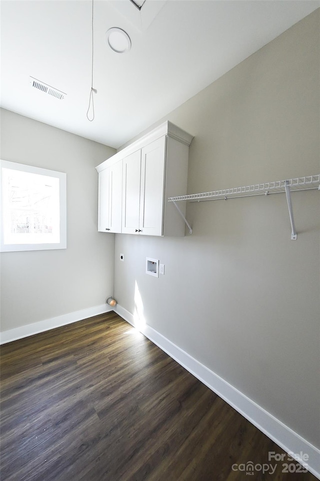 clothes washing area featuring hookup for a washing machine, visible vents, baseboards, cabinet space, and dark wood finished floors