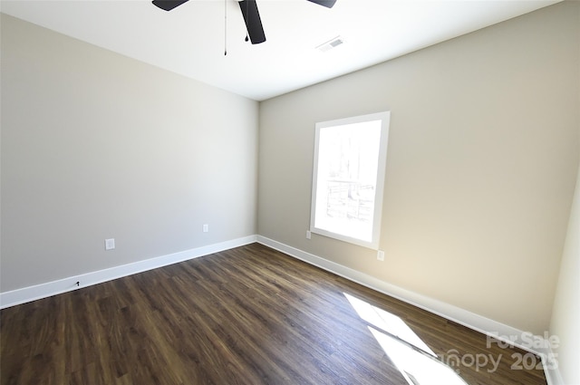 spare room featuring ceiling fan, dark wood-type flooring, visible vents, and baseboards