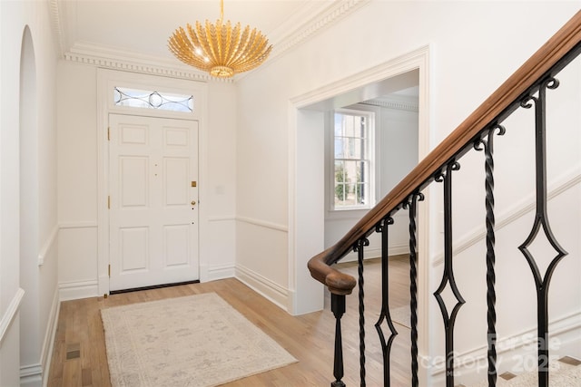 entrance foyer featuring light wood-style floors, visible vents, ornamental molding, and stairs