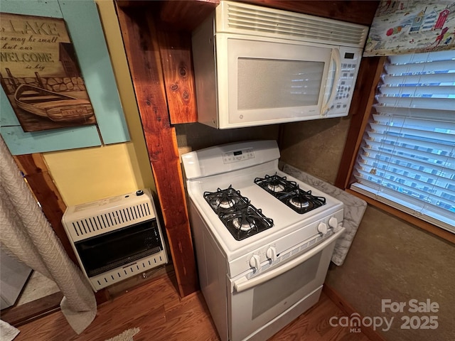 kitchen featuring hardwood / wood-style floors, heating unit, and white appliances