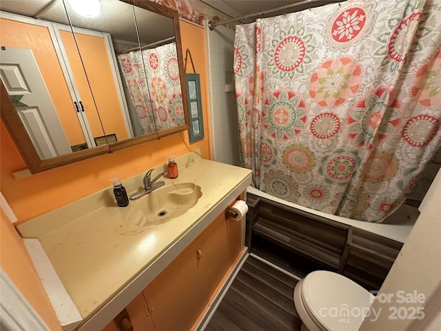 bathroom featuring hardwood / wood-style flooring, vanity, curtained shower, and toilet