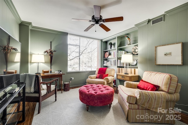 sitting room with crown molding and ceiling fan