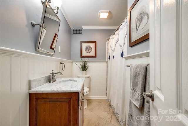 bathroom with ornamental molding, vanity, and toilet