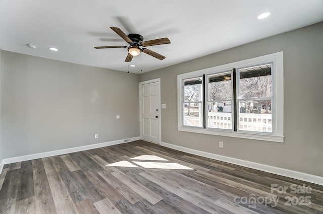 spare room with dark wood-type flooring and ceiling fan