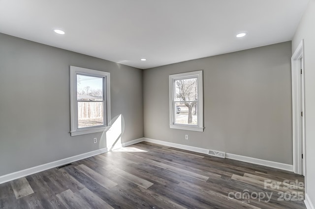 unfurnished room featuring dark hardwood / wood-style floors and a wealth of natural light