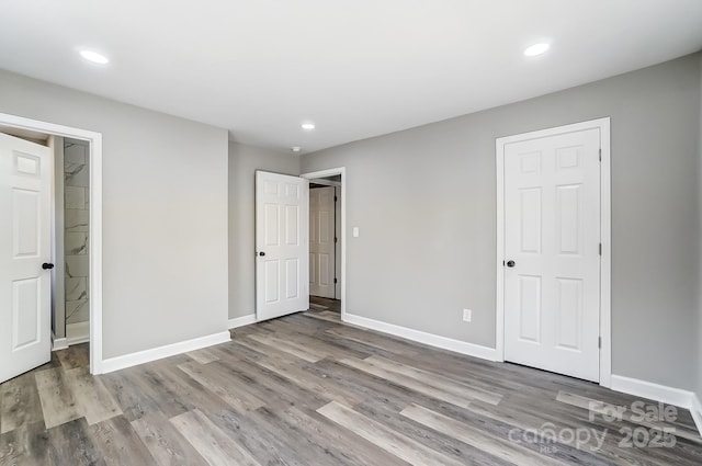 unfurnished bedroom featuring a walk in closet and light wood-type flooring