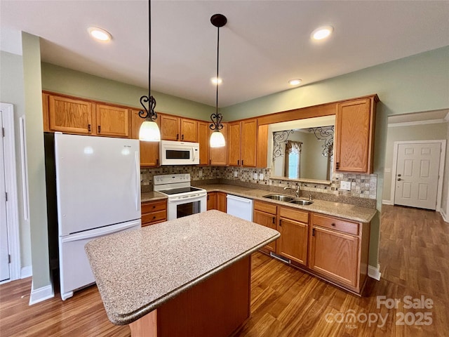 kitchen featuring a center island, white appliances, tasteful backsplash, sink, and decorative light fixtures