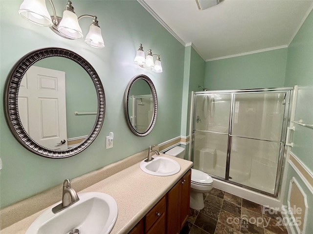 bathroom with toilet, vanity, an enclosed shower, and ornamental molding