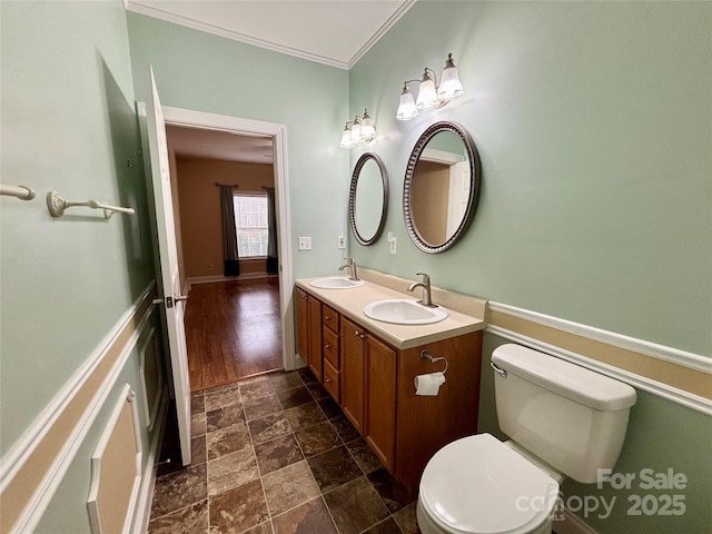 bathroom with vanity, toilet, and ornamental molding