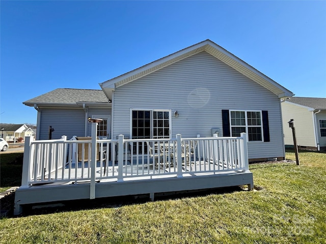 back of property with a deck and a lawn