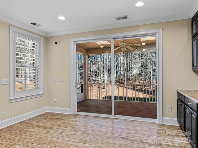 doorway featuring ornamental molding, ceiling fan, and light wood-type flooring