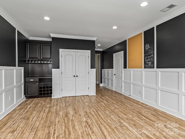 interior space with crown molding and light hardwood / wood-style floors