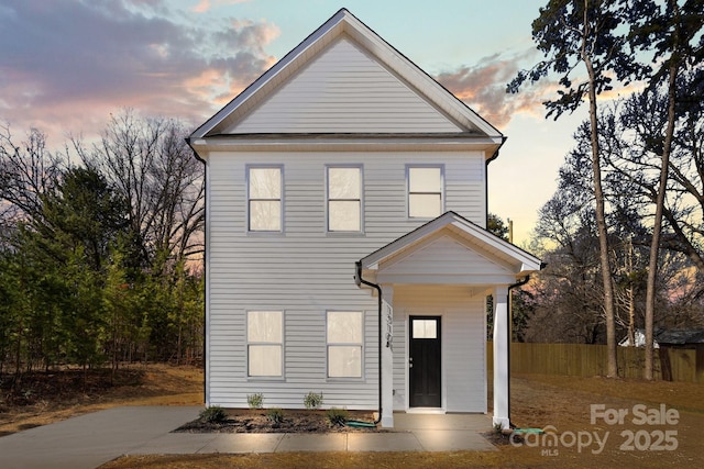 traditional-style home featuring fence