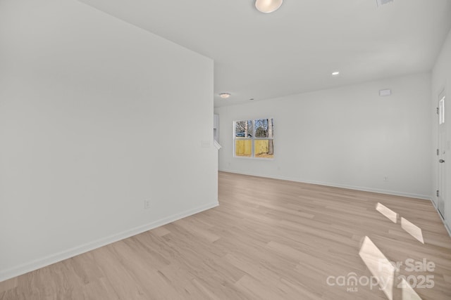 unfurnished room featuring light wood-style flooring and baseboards