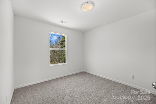 spare room featuring baseboards, visible vents, and carpet flooring