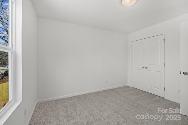 unfurnished bedroom featuring a closet, carpet, and baseboards