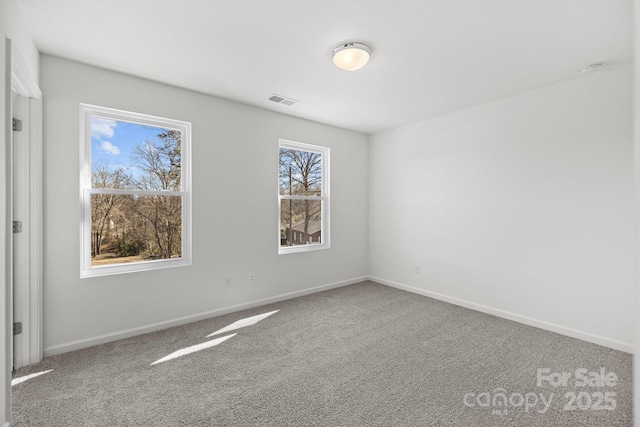 unfurnished room featuring baseboards, visible vents, and carpet flooring