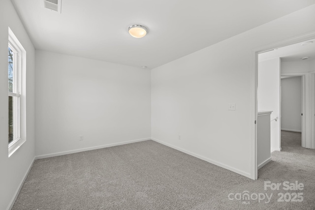 unfurnished room featuring light carpet, visible vents, and baseboards