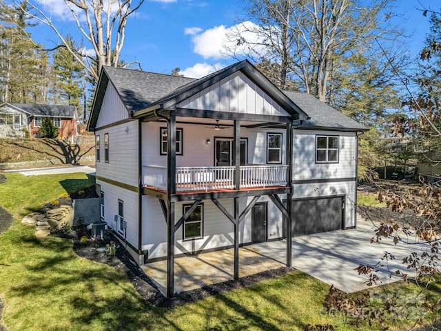 rear view of property featuring a lawn, ceiling fan, central AC, a patio area, and a garage