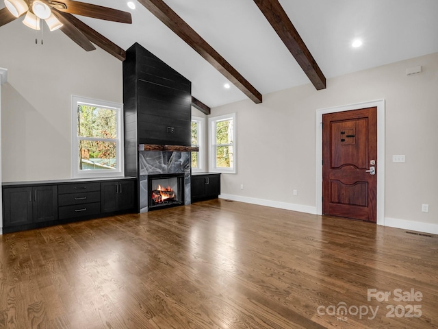 unfurnished living room featuring ceiling fan, beam ceiling, high vaulted ceiling, dark hardwood / wood-style floors, and a fireplace