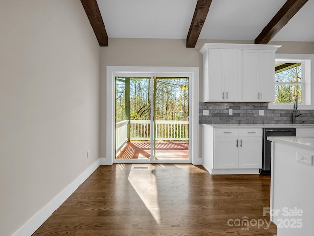 kitchen with white cabinetry, plenty of natural light, decorative backsplash, and beamed ceiling