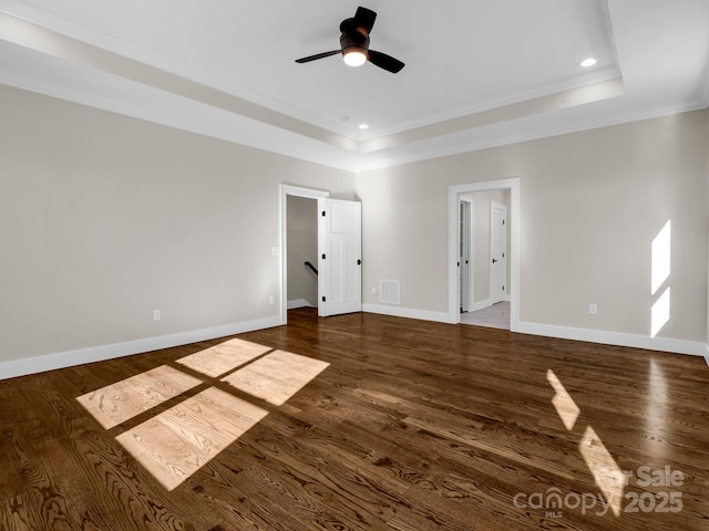 unfurnished room featuring dark hardwood / wood-style flooring, a tray ceiling, and ornamental molding