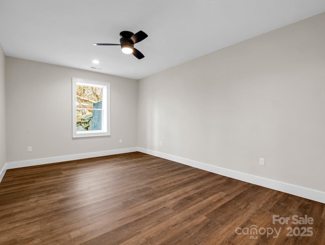 empty room with dark wood-type flooring and ceiling fan