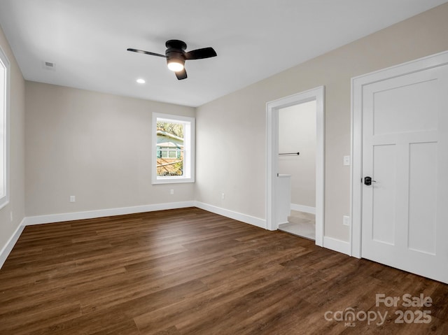 unfurnished bedroom with ceiling fan, ensuite bathroom, and dark hardwood / wood-style flooring