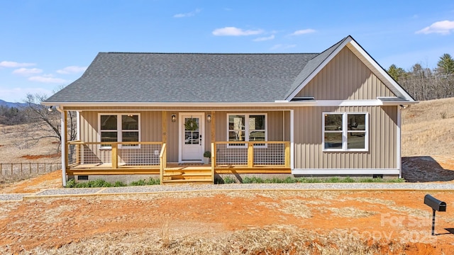 view of front facade featuring a porch, roof with shingles, and board and batten siding