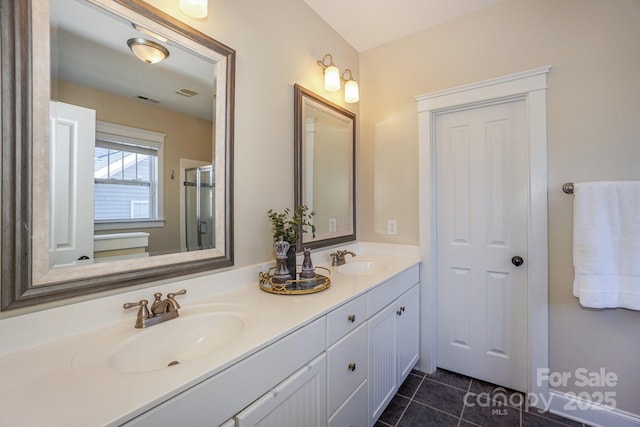 bathroom with double vanity, tile patterned flooring, visible vents, and a sink