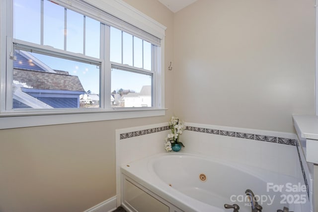 full bath featuring a jetted tub and baseboards